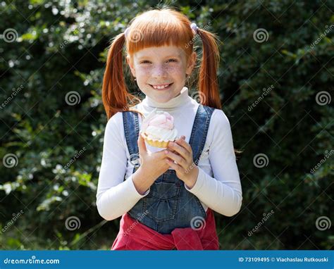 Het Kleine Roodharige Meisje Met Sproeten Houdt Een Cake Stock