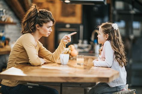 Young Mother Scolding Her Little Daughter At Home Stock Photo