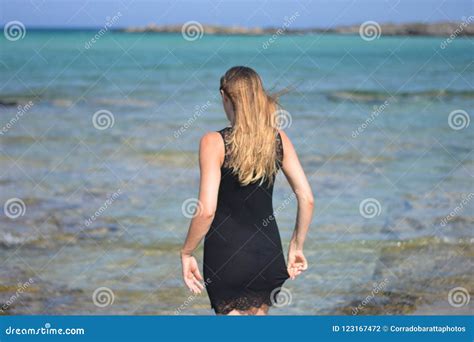 The Woman In Her Slip Is Entering The Transparent Water Of The Sea Stock Photo Image Of