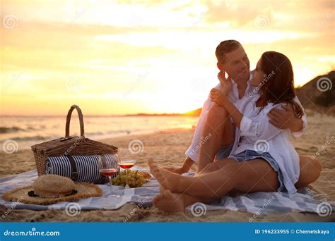 Lovely Couple Having Romantic Picnic On Beach At Sunset Stock Image