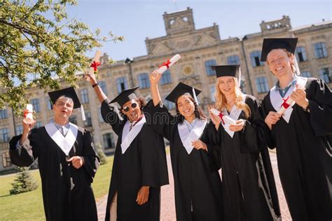 Graduating Students Jumping High With Their Caps Stock Image Image