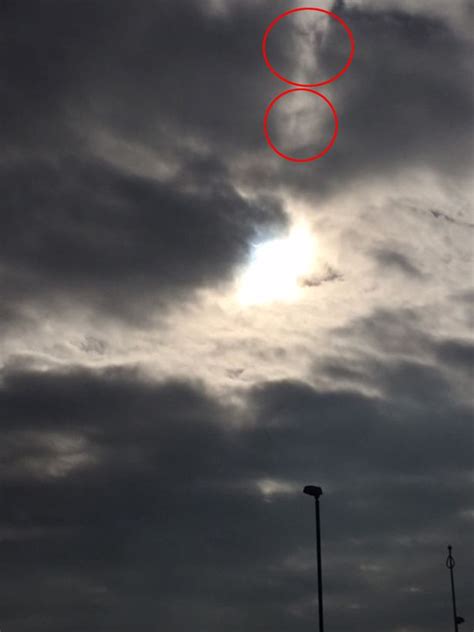 solar eclipse woman captures mystery face in cloud after taking picture of phenomenon mirror