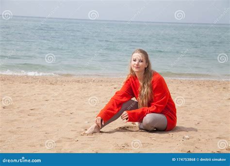 Beautiful Blonde Woman Sits On An Empty Beach By The Ocean Stock Photo Image Of Peace