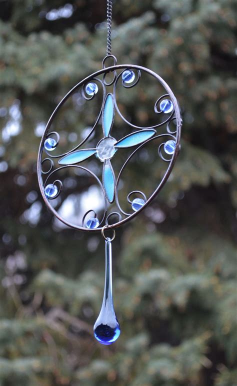 A Wind Chime Hanging From A Tree With Blue Glass Beads On Its Side