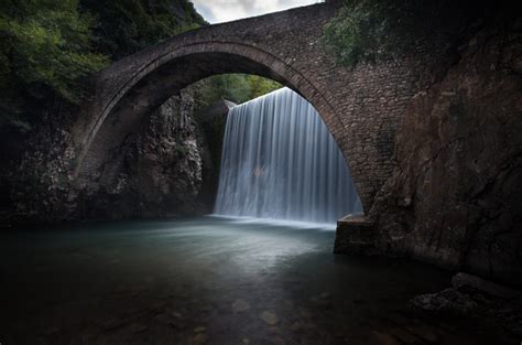 Arch Bridge Waterfall Of Paleokaria Near A Waterfall With Long Exposure