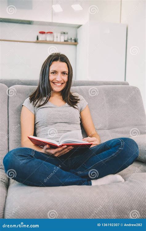 A Woman Sitting On A Sofa Holds A Book Stock Image Image Of Hobbies