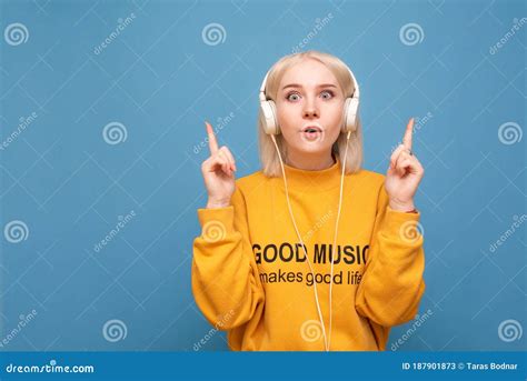 Portrait Of A Surprised Girl With Headphones On A Blue Background