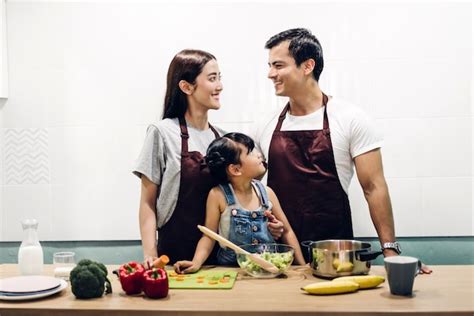 Feliz Padre De Familia Y Madre Con Hija Cocinar Y Preparar Comida