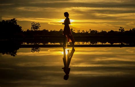 Silhouette Of Woman Sitting On Dock During Sunset · Free Stock Photo