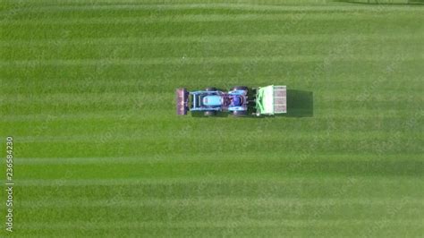 Large Lawn Mower Cutting Green Grass In A Soccer Field Top Down