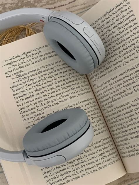 Two Headphones Sitting On Top Of An Open Book