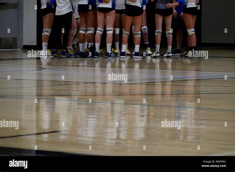 A Reflection Of Girl A Volleyball Team In A Huddle Reflected On The