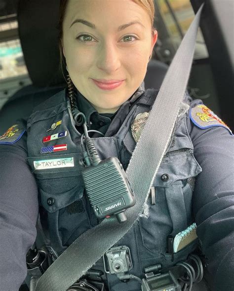 a female police officer sitting in the back seat of a car with a camera attached to her shoulder