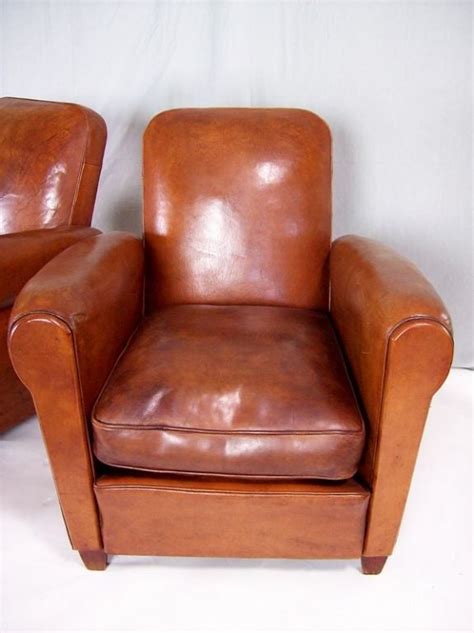 This club chair with luxurious top grain leather, domed camel back, padded rolled arms, and a deep plush seat, while also maintaining a sturdy base with a strong wooden frame. Pair of Small Deco Leather Club Chairs at 1stdibs