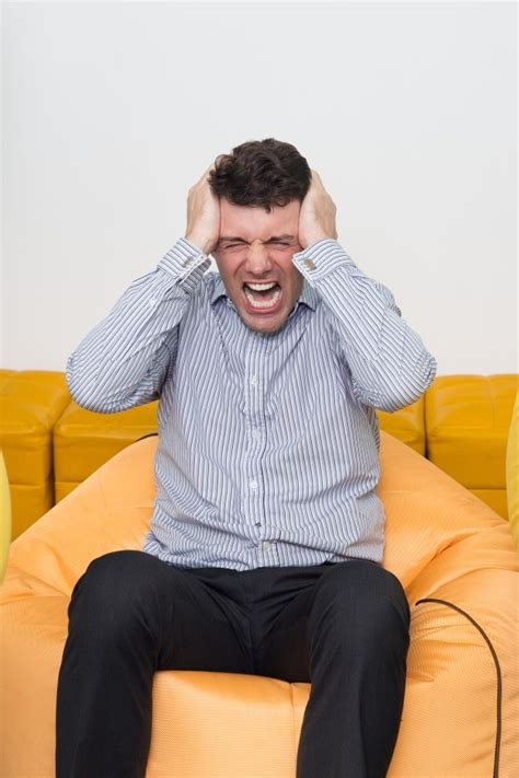 Mad Young Man Sitting On Beanbag In Office Crying Photo Free Download