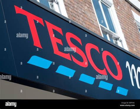 Looking Up At Tesco Supermarket Name And Logo Above The Entrance To One