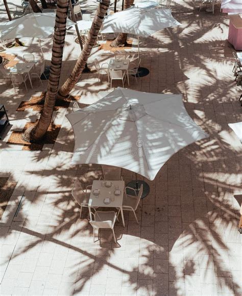 Aesthetic Outdoors Cafe With A White Umbrella And White Small Tables