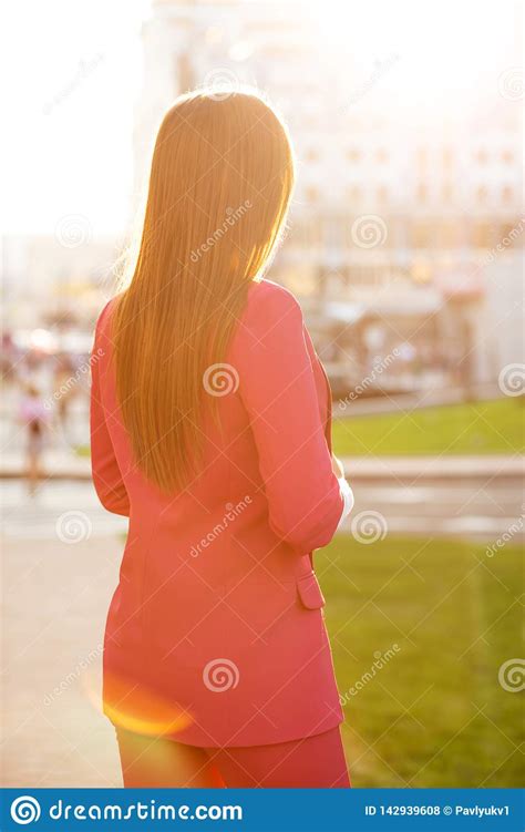 Pretty Brunette Model In Pink Costume Looking At The City Buildings