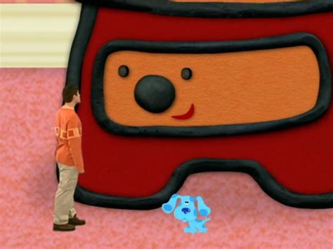A Man Is Standing In Front Of A Large Cartoon Bear On The Floor Next To