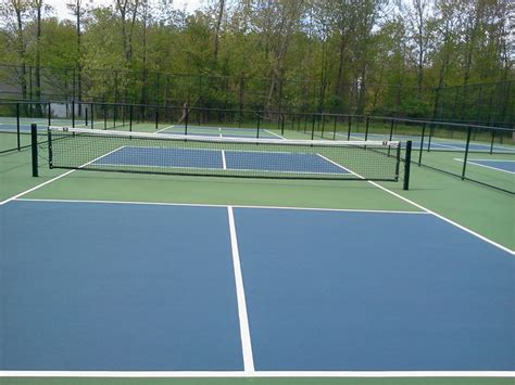 There Are Two Tennis Courts That Have Blue And White Lines On Each Side