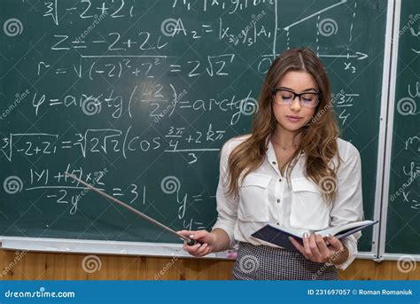 attractive female teacher in glasses near blackboard with math calculations stock image image