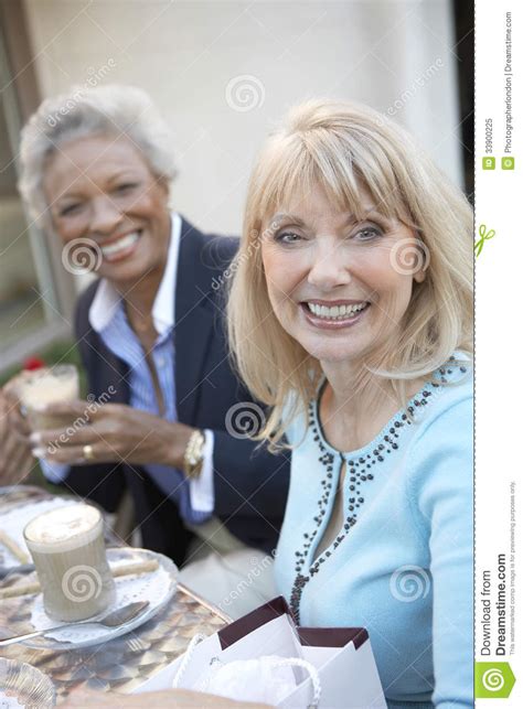 Two Friends Looking At Each Other While Lying Head To Shoulder Stock