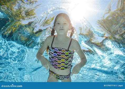 Child Swims In Pool Underwater Girl Has Fun In Water Stock Photo