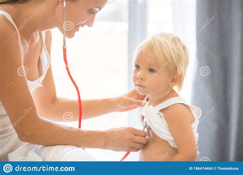 Pediatrician Examining Baby Boy Doctor Using Stethoscope To Listen To