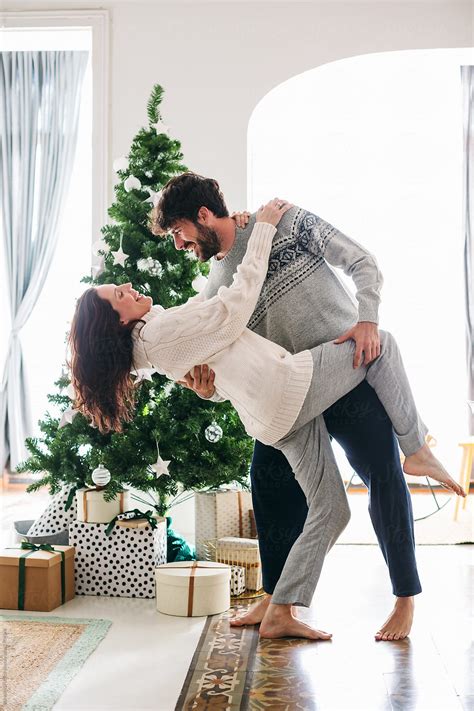 Couple In Love Dancing In Front Of Christmas Tree At Home By Stocksy
