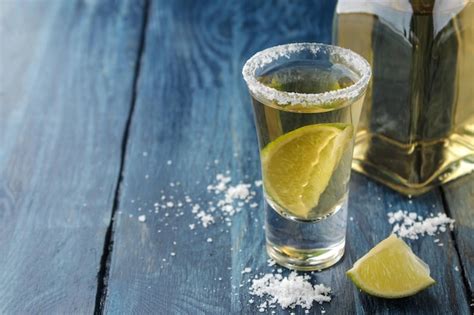 Premium Photo Gold Tequila In A Glass With Salt And Lime On A Blue Wooden Table Alcoholic
