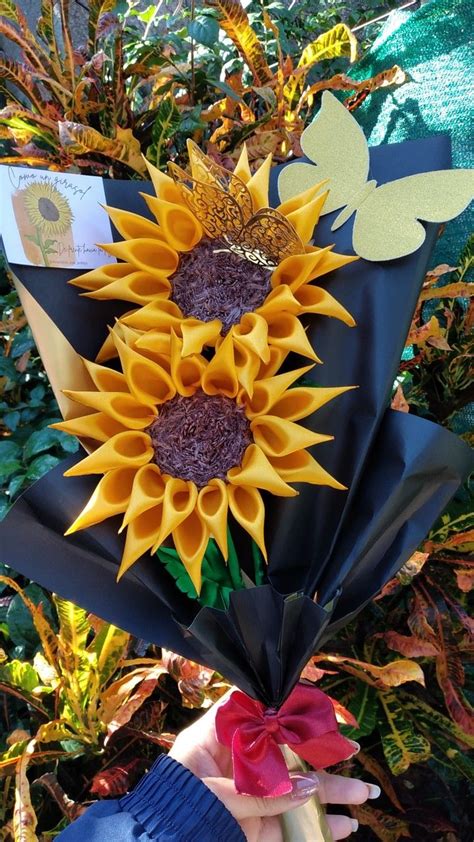 A Bouquet Of Sunflowers Is Being Held By Someones Hand With