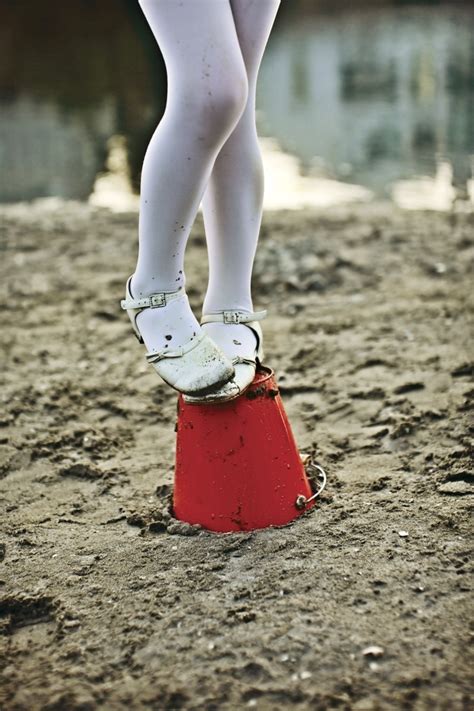 Getty Girl In Tights And White Shoes Standing On Red Bucket