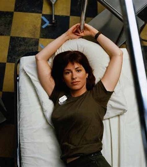 A Woman Laying On Top Of A Bed Next To A Metal Handrail In A Room With