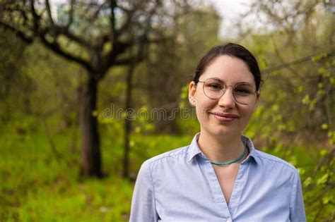 Portrait Of A Young Beautiful Brunette Woman A Nerd Scientist With Glasses In The Forest Looking