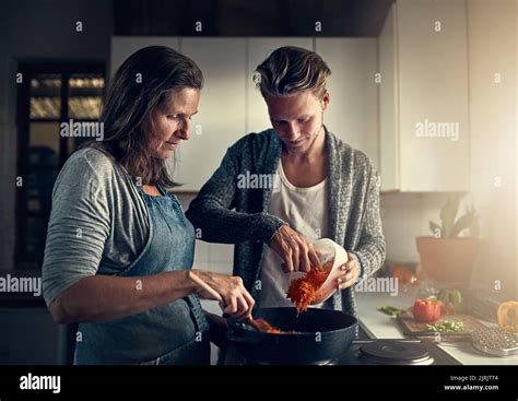 Cooking Up Something Special Together A Mother And Her Adult Son Cooking Together In Their