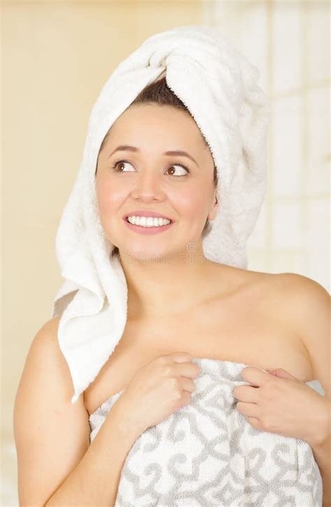 Beautiful Smiling Young Woman With A White Towel Covering Her Head Is Holding With Both Hands