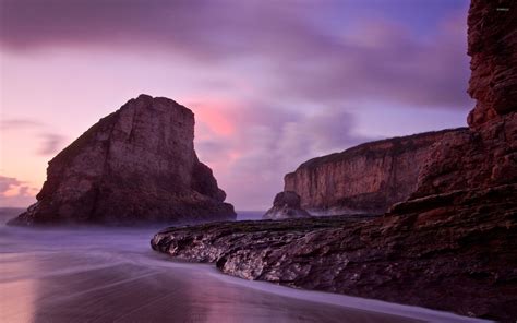 Purple Sunset Over The High Rocky Shore Wallpaper Beach