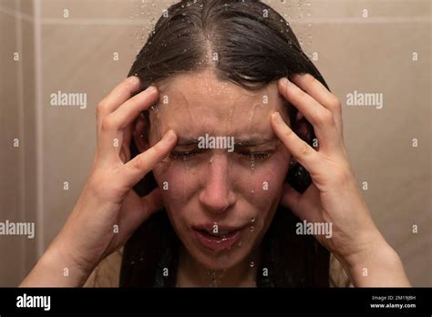 Young Woman In Shower With Water Running Down Her Face Holding Her Head Concept Holding Her