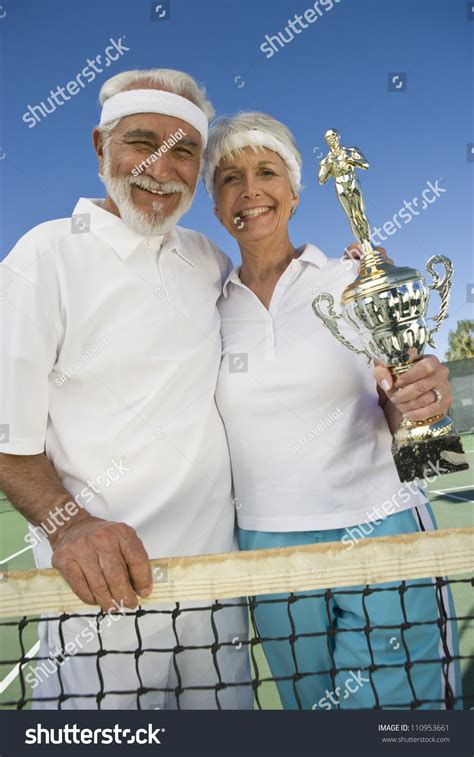Cheerful Senior Tennis Players Holding Trophy Stock Photo 110953661