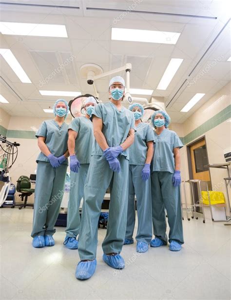 Medical Team In Scrubs Standing Inside Operation Room Stock Photo