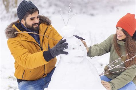 Couple Having Fun Making Snowman While On Winter Vacation Stock Image Image Of Cheerful