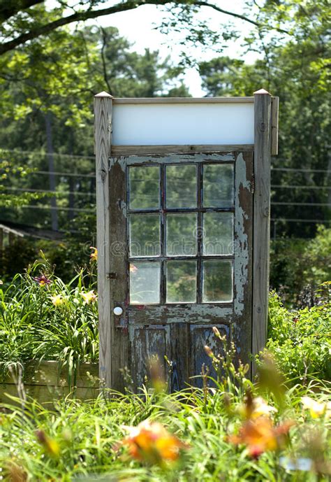 Just prop up a door against your fence and make a creative doorway for it. Old Wooden Door In Daylily Garden Stock Photo - Image of ...