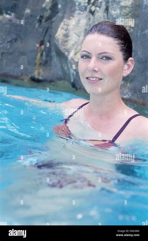 therme swimming pool woman stand water view camera smiles enjoys portrait 20 30 years