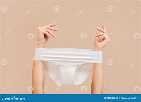 elegant female hands with panties stretched over them beige background copy space stock image