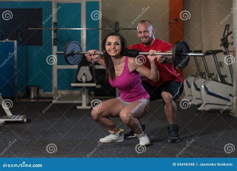 Woman With Personal Trainer At Barbell Squat Stock Photo Image Of