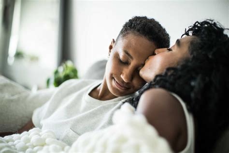 Lesbian Couple At Home Snuggling Under Blanket Mundo Negro
