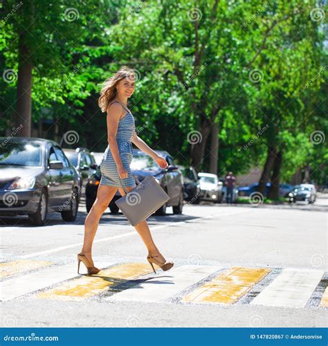 Young Beautiful Woman In A Blue Short Dress Walking On The Road Stock