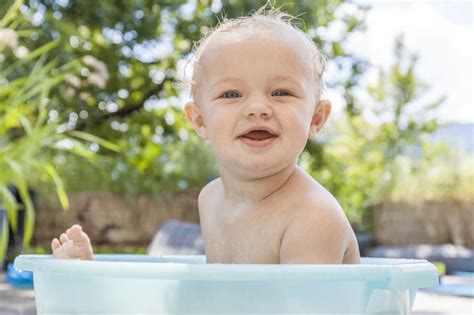 Boy Sitting In Baby Bathtub Stock Photo