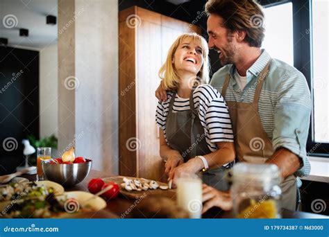 Happy Couple Cooking Together Husband And Wife In Their Kitchen At Home Preparing Healthy Food