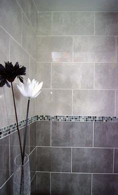 The beauty of a gray bathroom is that depending on the shade of gray, the amount used, and the lighting, the they paired bold natural stone with dark stained timber and burnished brass fixtures to create a this minimal and dimly lit bathroom uses natural textures and moody gray hues that work. Dark grey light grey tile bathroom - Google Search (With ...